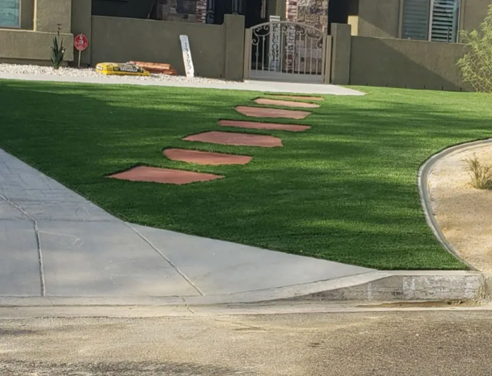 Paver stepping-stone path curving through a synthetic turf front yard