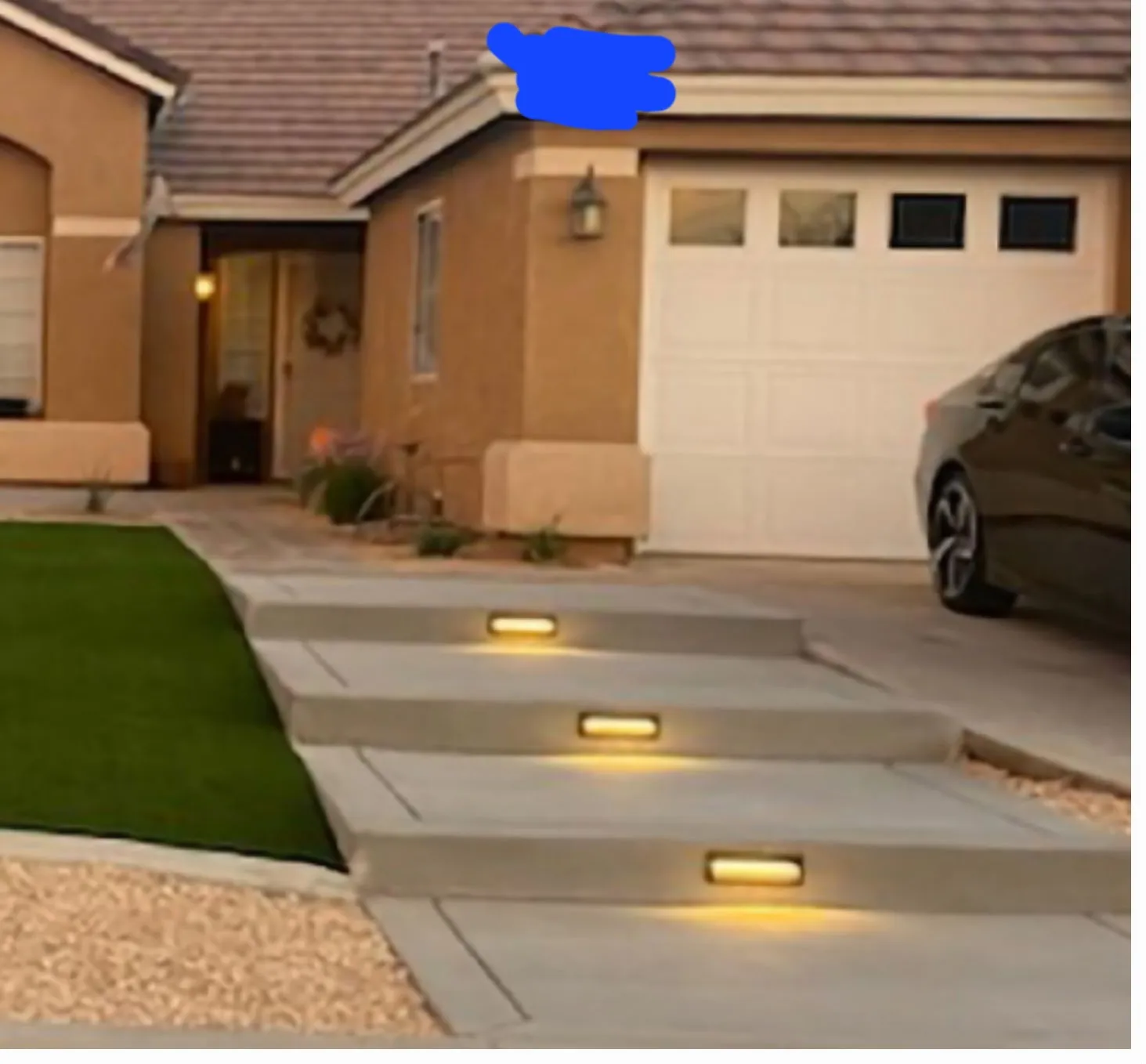 Low-voltage step lighting along a front entry walkway at dusk