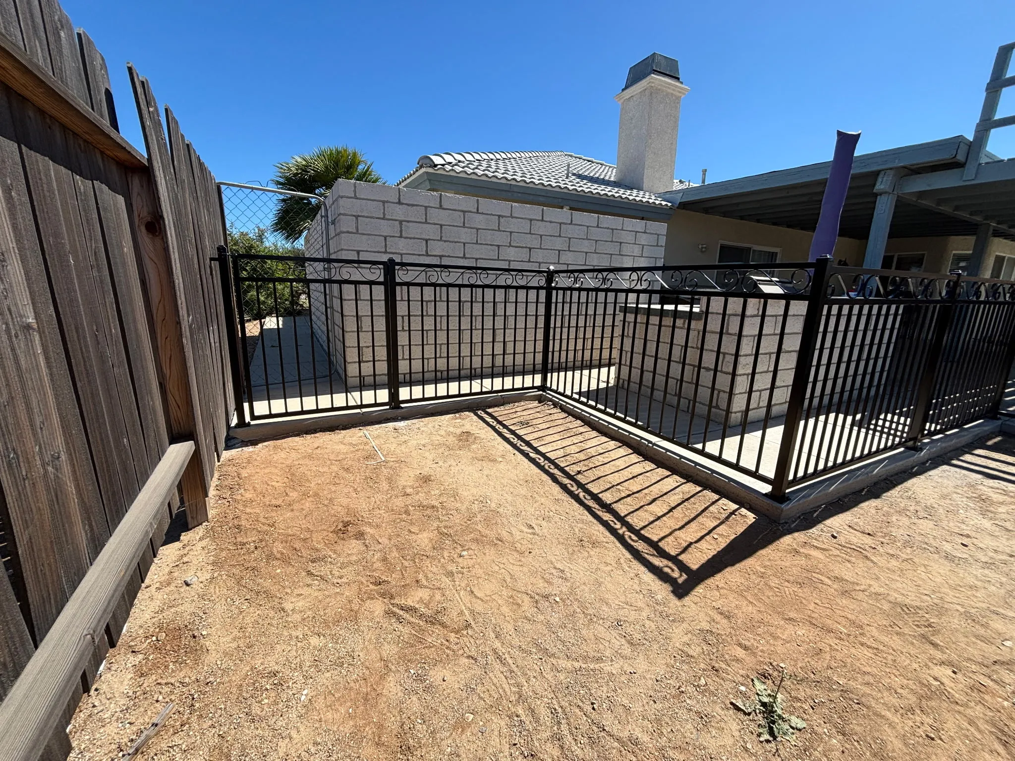 Wrought iron fence and gate framing a side patio area