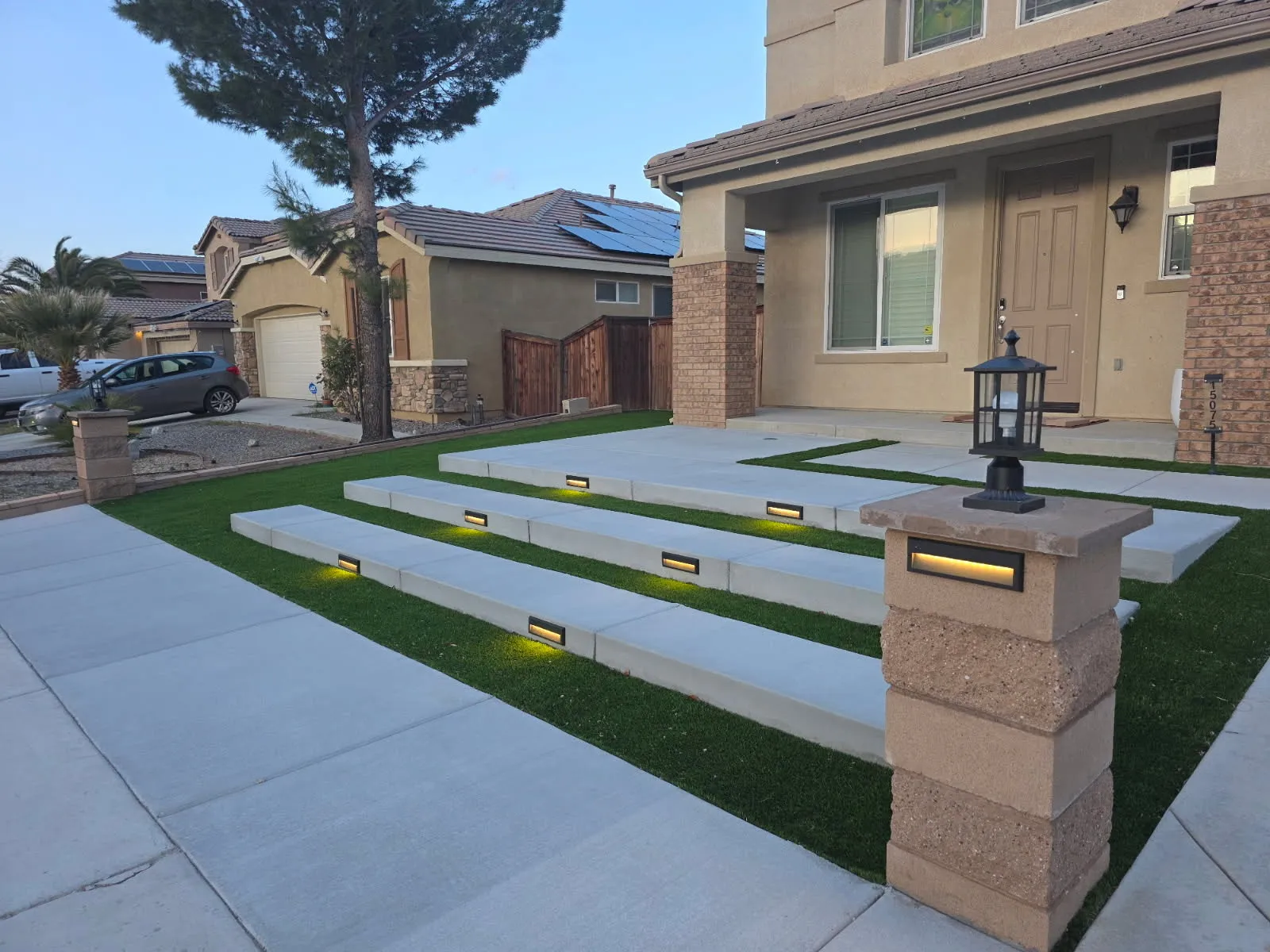 Artificial grass steps with integrated lighting and illuminated entry pillars